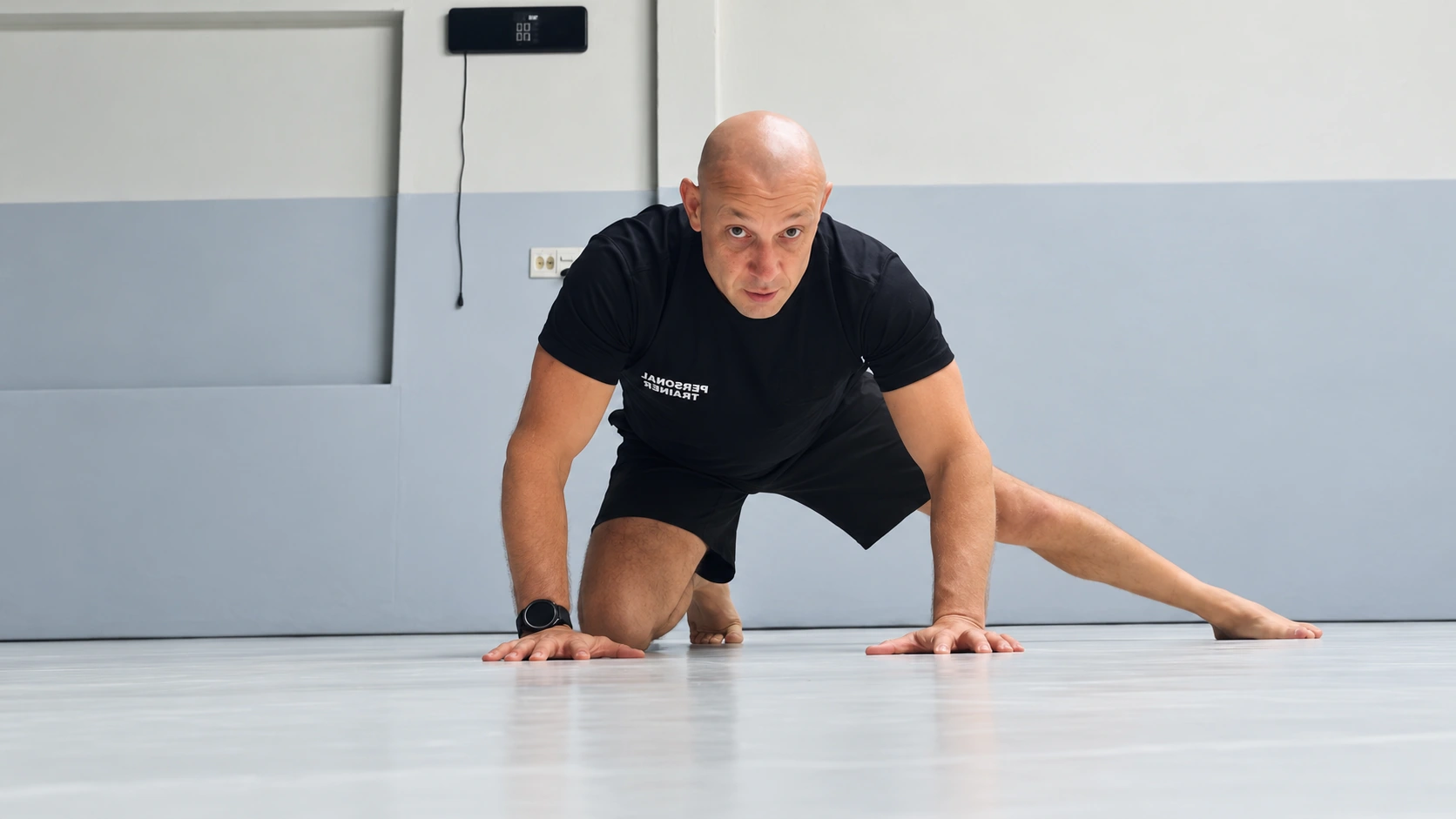 Adductor rockback exercise from The 30-Day BJJ Mobility Reset: one knee supported on the mat and the other leg extended to the side