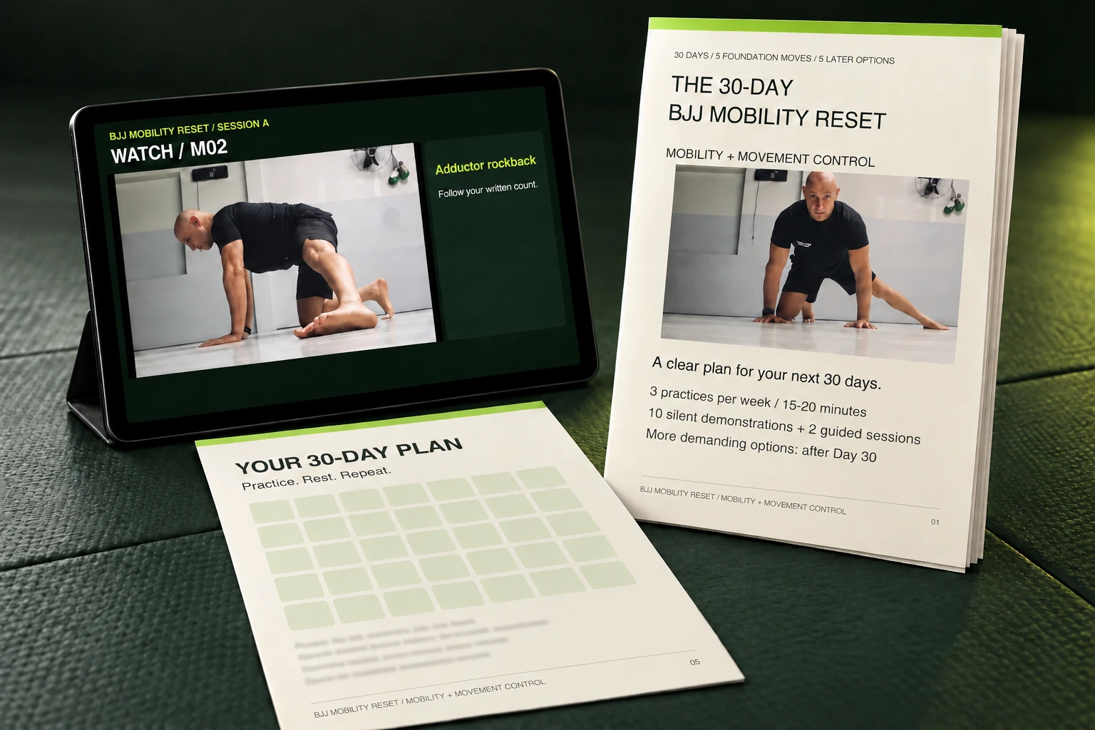Illustrative BJJ Mobility Reset tablet, member guide and 30-day plan on a green mat